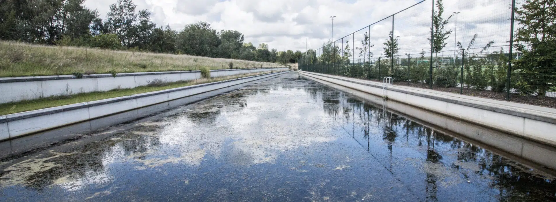 Betonnen keerwand gebruikt als waterkeringen bij een sportcomplex